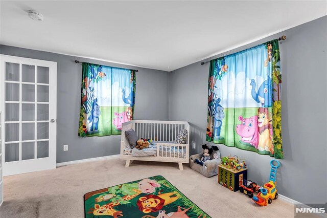 bedroom with carpet floors and a nursery area