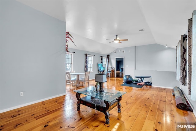 living room featuring ceiling fan, vaulted ceiling, and wood-type flooring