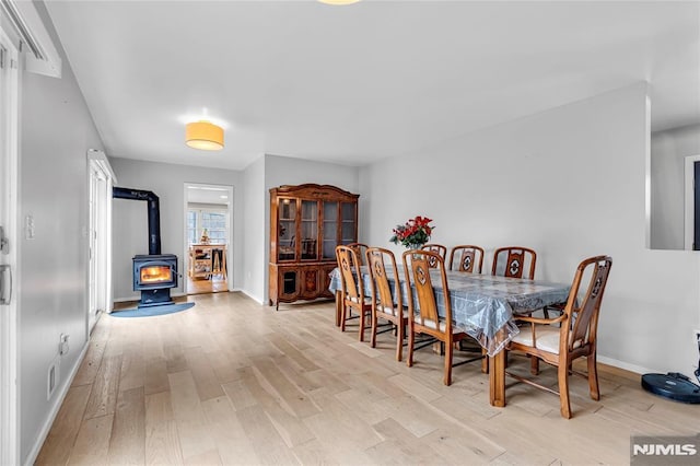 dining space featuring a wood stove and light hardwood / wood-style flooring