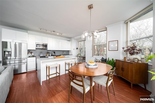 dining room with dark wood-type flooring and an inviting chandelier