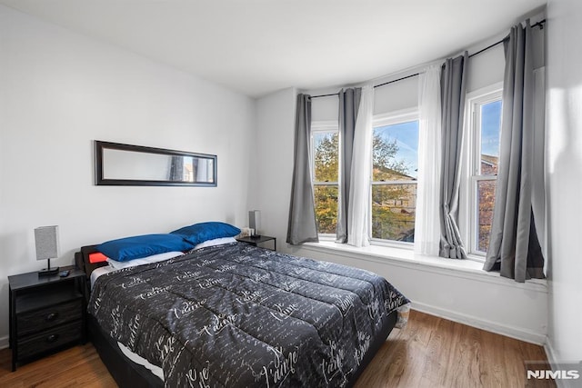 bedroom featuring hardwood / wood-style flooring and multiple windows