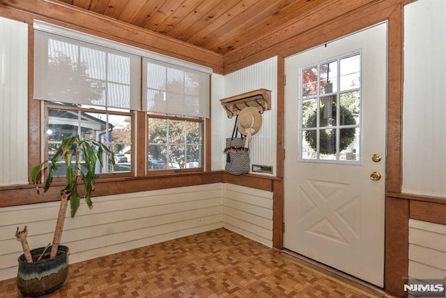 doorway featuring wood walls, wood ceiling, and parquet flooring