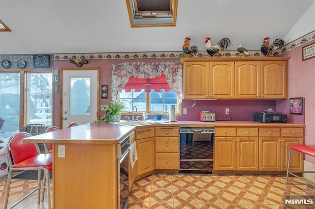 kitchen featuring sink, black dishwasher, and lofted ceiling