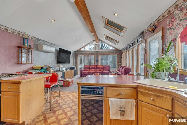 kitchen with lofted ceiling with beams, a breakfast bar, ceiling fan, a wall mounted air conditioner, and sink