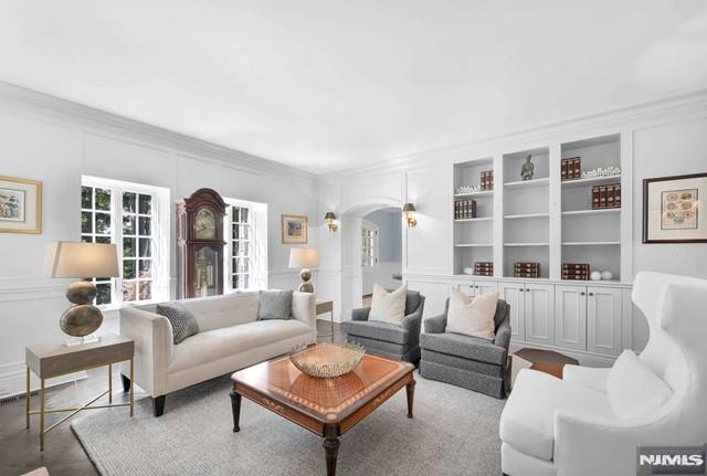 living room featuring built in features and ornamental molding