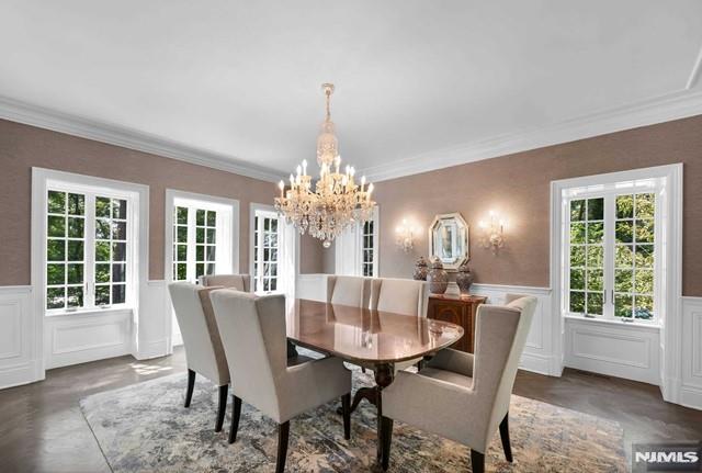 dining space with crown molding and an inviting chandelier