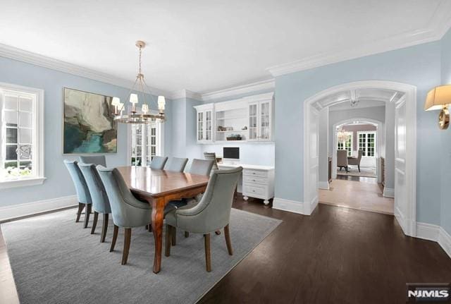 dining room featuring a notable chandelier, dark hardwood / wood-style flooring, and crown molding