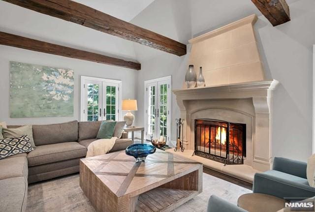 living room featuring beam ceiling and french doors