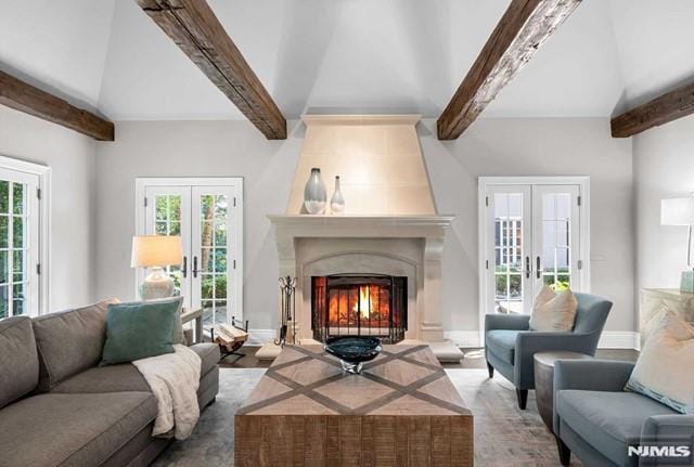 living room with a large fireplace, french doors, and plenty of natural light