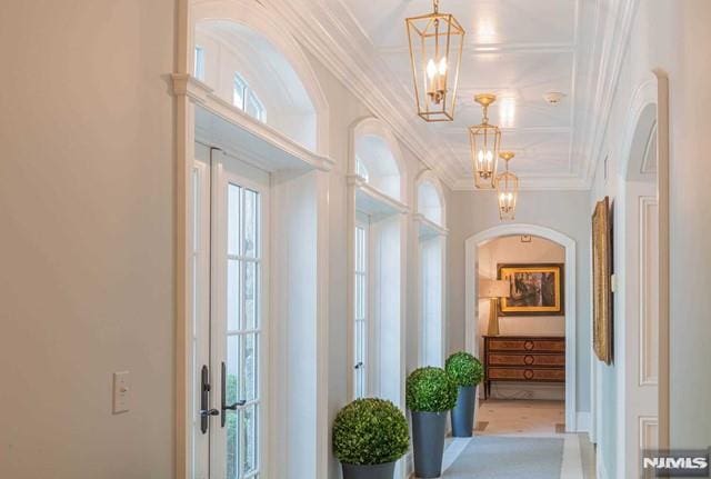 hallway featuring an inviting chandelier and ornamental molding