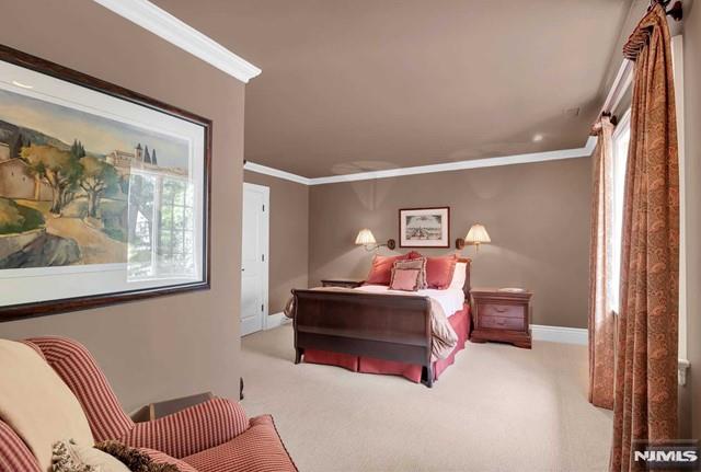 bedroom with ornamental molding, light carpet, and multiple windows