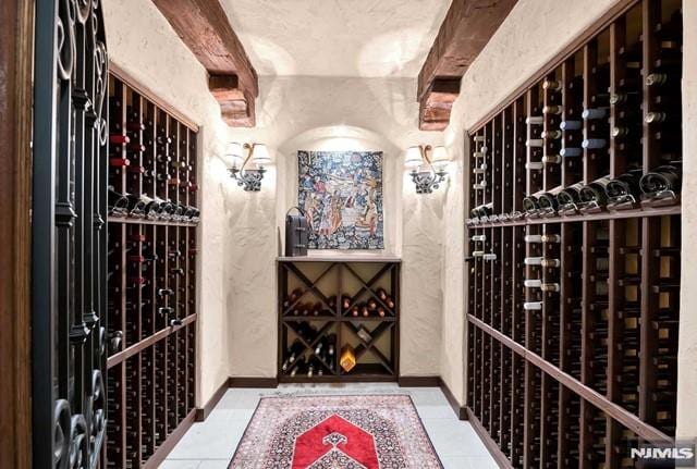 wine area with beam ceiling and light tile patterned floors