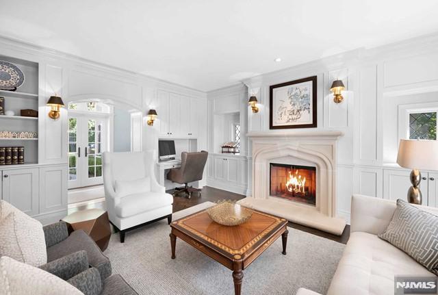 living room featuring built in features, crown molding, and french doors