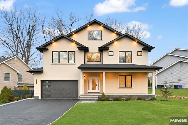 view of front of property with a porch, a garage, and a front yard