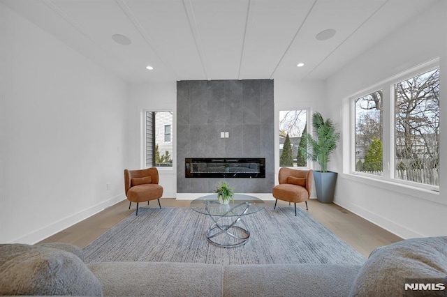 sitting room featuring a tile fireplace and wood-type flooring