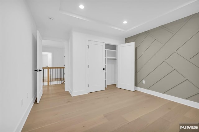 unfurnished bedroom featuring wood-type flooring and a closet