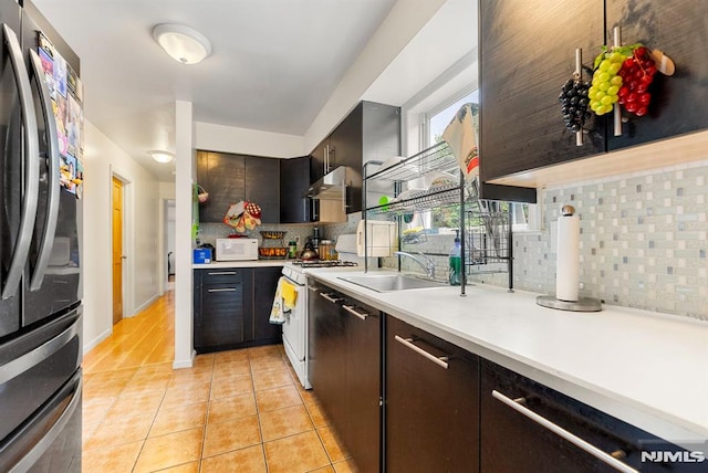 kitchen featuring white appliances, sink, exhaust hood, and tasteful backsplash