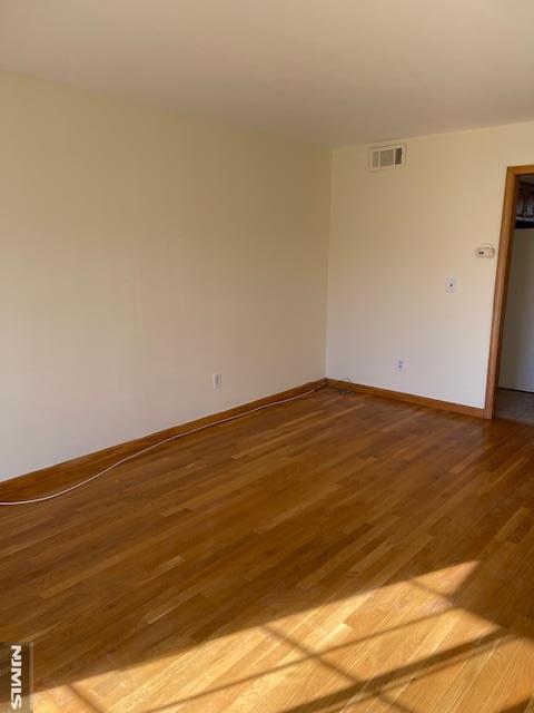 unfurnished room with hardwood / wood-style flooring