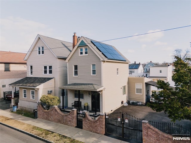 view of front of home with covered porch and solar panels