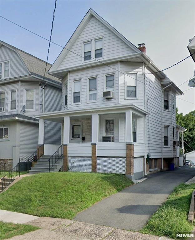 view of front of property featuring a front lawn and cooling unit