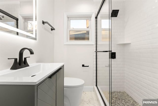 bathroom featuring vanity, toilet, and an enclosed shower