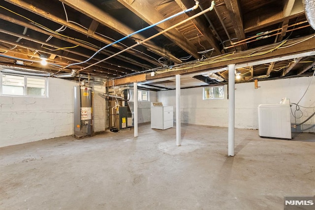 basement featuring gas water heater and separate washer and dryer