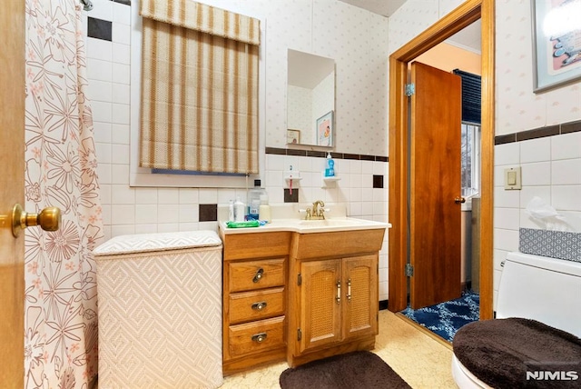 bathroom with vanity, tile walls, and toilet