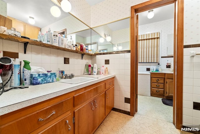 bathroom with vanity and tile walls