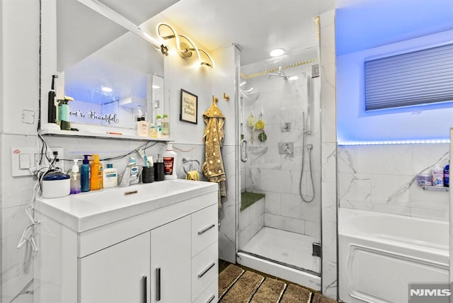 bathroom with tasteful backsplash, plus walk in shower, and vanity