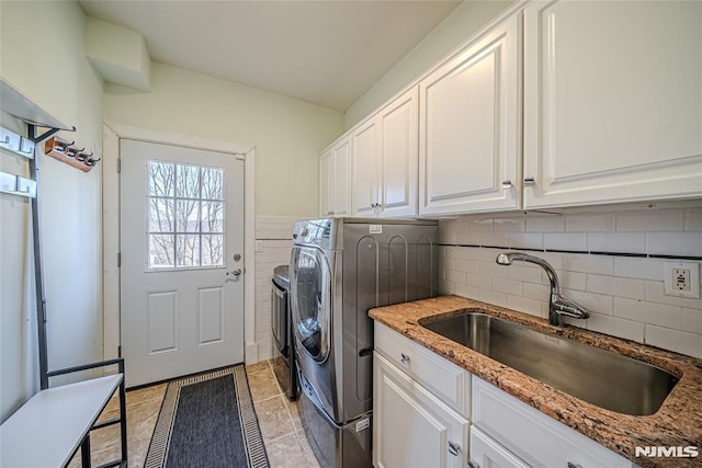 laundry area featuring cabinets, light tile patterned floors, separate washer and dryer, and sink