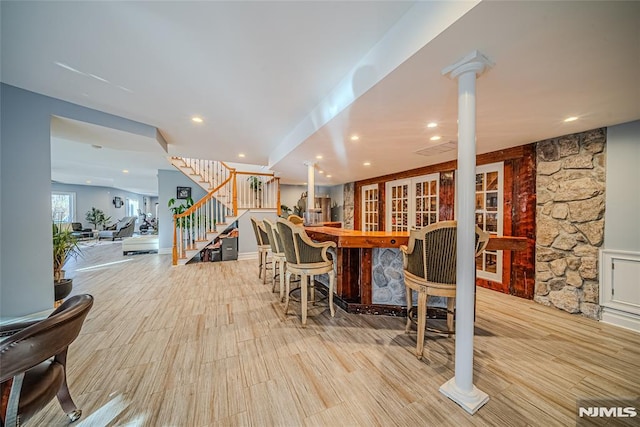 dining space featuring bar area and light hardwood / wood-style flooring