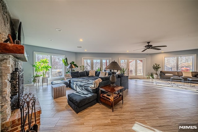 living room with a fireplace, ceiling fan, and a healthy amount of sunlight