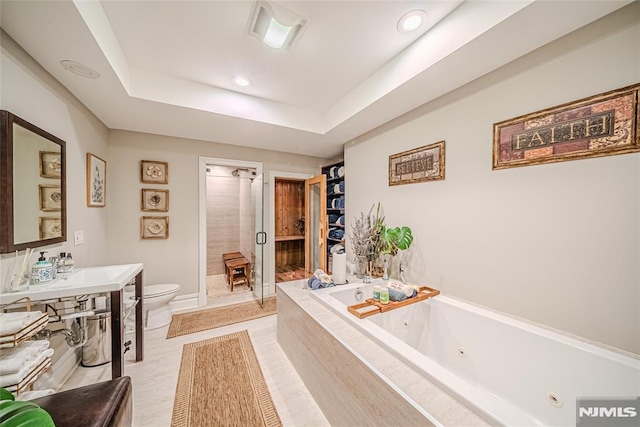 bathroom with toilet, separate shower and tub, and a raised ceiling