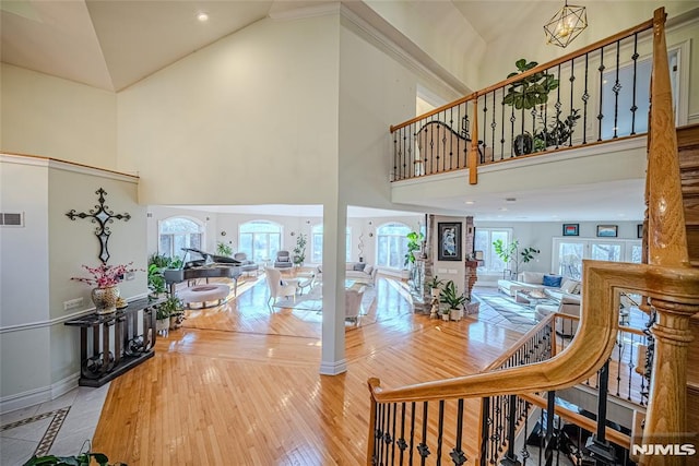 interior space featuring hardwood / wood-style flooring, a towering ceiling, and an inviting chandelier