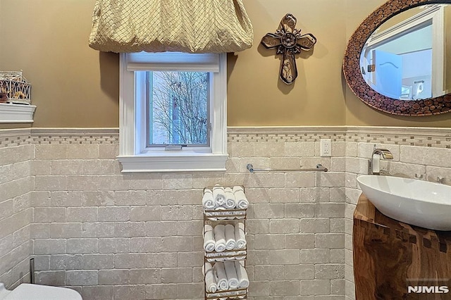 bathroom with vanity and tile walls