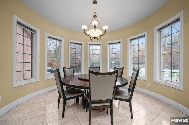 tiled dining room with an inviting chandelier