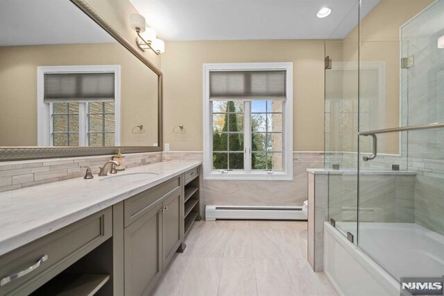 bathroom with vanity, enclosed tub / shower combo, and baseboard heating