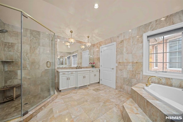 bathroom with plus walk in shower, vanity, and tile walls