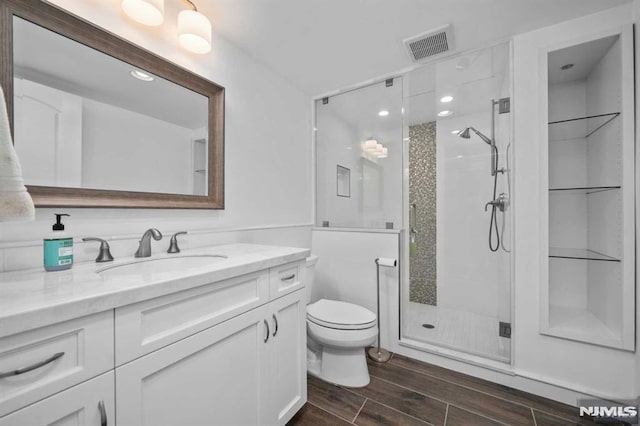 bathroom with vanity, an enclosed shower, and toilet