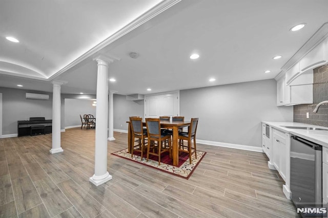 dining area featuring decorative columns, sink, and a wall mounted air conditioner