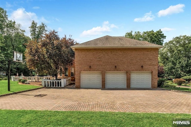 view of side of home featuring a lawn and a garage