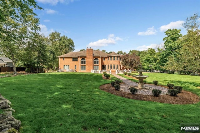 rear view of property with a yard