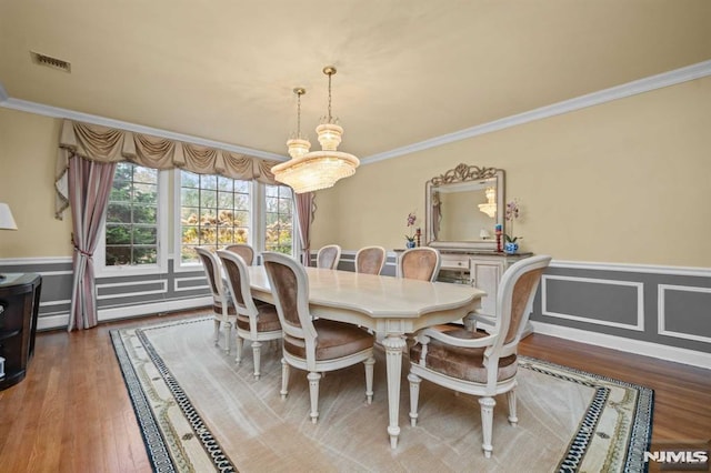 dining space featuring hardwood / wood-style floors, ornamental molding, and a baseboard radiator