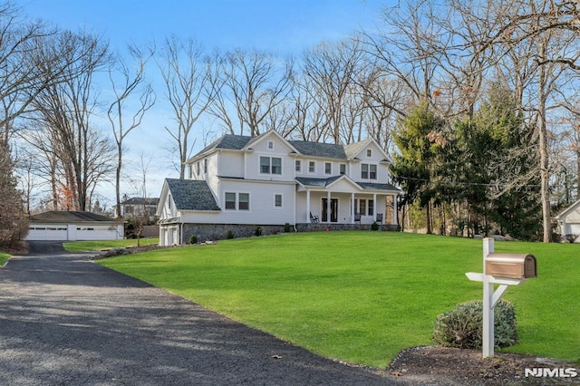 view of front facade featuring a porch, a garage, and a front lawn