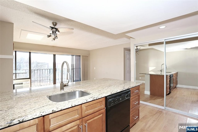 kitchen featuring sink, light stone countertops, black dishwasher, and ceiling fan