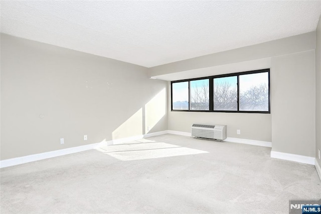 empty room with a wall unit AC and a textured ceiling