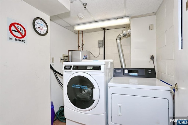 clothes washing area featuring water heater and separate washer and dryer