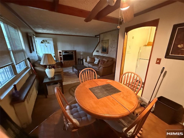 dining space featuring ceiling fan, beam ceiling, and ornamental molding