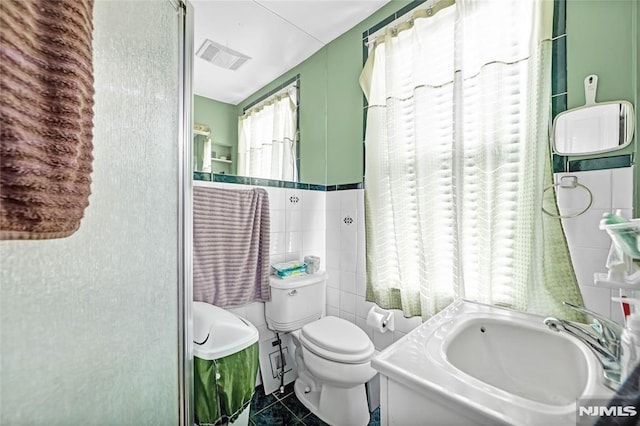 bathroom featuring tile patterned flooring, a shower, and toilet