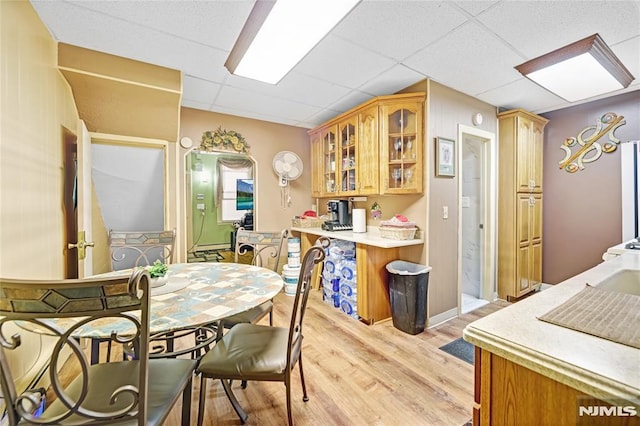 kitchen featuring a paneled ceiling and light hardwood / wood-style flooring